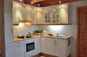 uma cozinha com armários brancos e um lavatório em Sommerhaus am Meer em Barsfleth