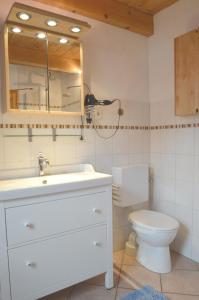 uma casa de banho com um lavatório branco e um WC. em Sommerhaus am Meer em Barsfleth