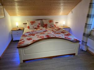 um quarto com uma grande cama branca com flores em Sommerhaus am Meer em Barsfleth