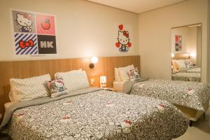 um quarto com 2 camas e almofadas Hello Kitty em Trento Hotel Guaíra by Unna em Guaíra