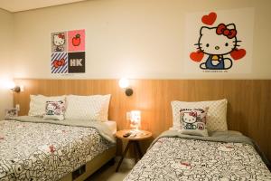 a bedroom with two beds and a hello kitty sticker on the wall at Trento Hotel Guaíra by Unna in Guaíra