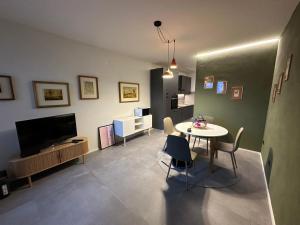 Una sala de estar con una mesa y un televisor. en Alloggio con Terrazza, en Villanova Mondovì