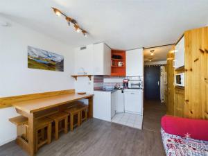 een keuken met witte kasten en een houten tafel bij Appartement 2 Pièces - Balcon Ouest, Proche Pistes et Commerces - 4 Pers, 2* - FR-1-398-516 in La Rosière