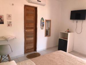 een slaapkamer met een bed en een houten deur bij Casa e suítes da Vava in Trairi +5 foto's