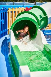 una mujer montando un tobogán de agua en una piscina en Serenè Resort en Steccato