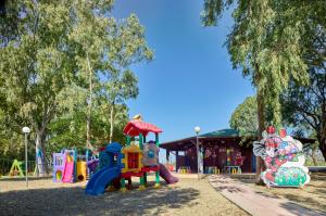 - une aire de jeux dans un parc avec des équipements de jeux dans l'établissement Serenè Resort, à Steccato