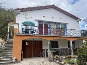 uma casa branca com varanda e escadas em Appartement Prats-de-Mollo-la-Preste, 3 pièces, 6 personnes - FR-1-659-60 em Prats-de-Mollo-la-Preste