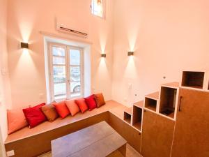 a room with a bench with red pillows and a window at Charmant Studio Cosy Central in Manosque