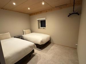 a room with two beds and a window at ARTISANAL in Naoshima