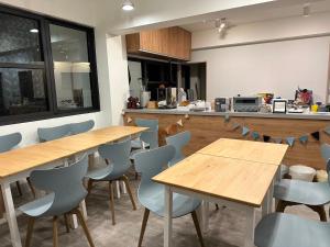 una cocina con mesas de madera y sillas azules en Oceans Explore Hostel en Green Island