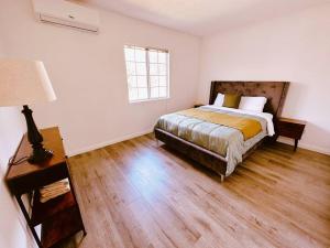 1 dormitorio con 1 cama y suelo de madera en Movie Nest - 2BR - Huge Backyard w Grill, en La Puente