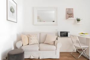 uma sala de estar branca com um sofá e uma mesa em Charming Milanese Aparment em Milão