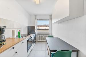 a kitchen with a table and some green chairs at MONTEURWOHNUNG Ebersbach EB03 RAUMSCHMIDE Apartments in Ebersbach an der Fils