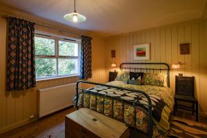 a bedroom with a bed and a window at Stable Cottage, Gartocharn, Loch Lomond in Alexandria