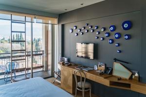 a bedroom with a bed and a desk and a television at New Hotel in Athens