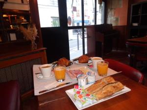 une table avec une assiette de nourriture et de jus d'orange dans l'établissement Hôtel les Degrés de Notre Dame, à Paris