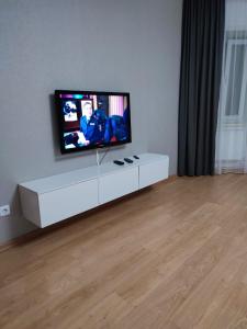 a living room with a flat screen tv on a white cabinet at Апартаменты Жаяу Мусы 7А in Pavlodar