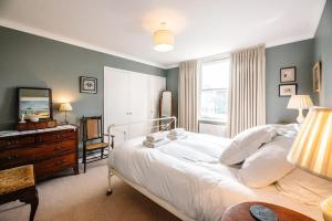 ein Schlafzimmer mit einem Bett, einer Kommode und einem Fenster in der Unterkunft 29 Wentworth Road, Aldeburgh in Aldeburgh