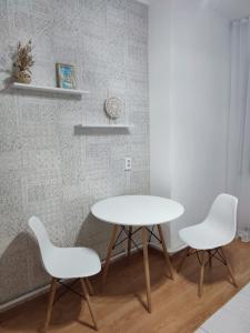 a table and two white chairs in a room at Апартаменты Жаяу Мусы 7А in Pavlodar