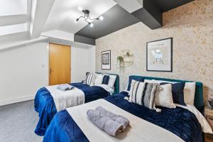 デューズバリーにあるLovely Yorkshire Duplex - Sleeps 6 - Netflixの青と白の部屋のベッド2台