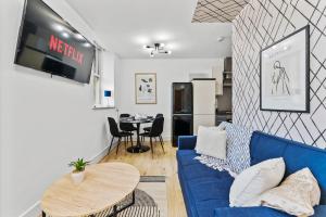 uma sala de estar com um sofá azul e uma mesa em Lovely Yorkshire Duplex - Sleeps 6 - Netflix em Dewsbury