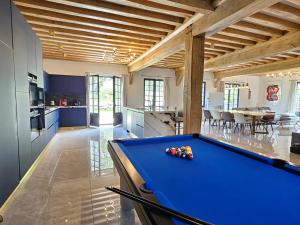 a kitchen with a pool table in a room at Villa d'exception, 5 chambres, 20m plage, spa. in Bénerville-sur-Mer