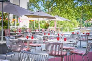 um grupo de mesas e cadeiras com copos de vinho em Hotel Lyon-ouest em Lyon