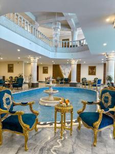 a lobby with a fountain and chairs and a table at Vista Haql Hotel in Al Humaizah