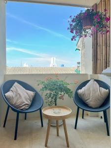 2 stoelen en een tafel op een balkon bij L’Oasis Nanai in Patong Beach
