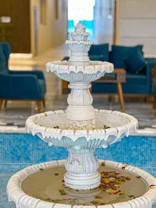a white fountain in the middle of a room at Vista Haql Hotel in Al Humaizah