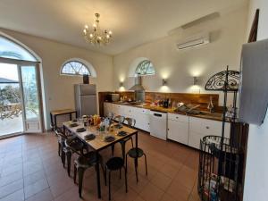 kuchnia ze stołem i krzesłami w pokoju w obiekcie VILLA BELVEDERE D'AJACCIO, VILLA ENTIERE VUE MER POUR 2 à 10 VOYAGEURS w Ajaccio