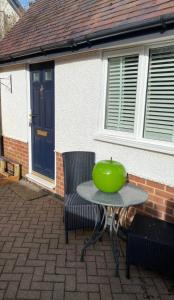 a green apple sitting on a table in front of a house at Elegant home near Stratford upon avon in Alcester