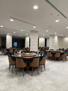 a large room with tables and chairs in a building at Vista Haql Hotel in Al Humaizah