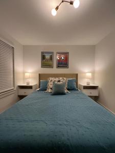 1 dormitorio con 1 cama grande y edredón azul en Closetobroadwayairportoprymillsgameroom, en Nashville