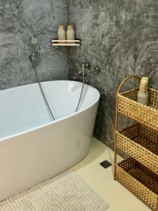 巴東海灘的住宿－L’Oasis Nanai，浴室设有白色浴缸。