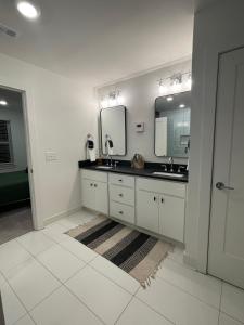 een badkamer met 2 wastafels en een grote spiegel bij Closetobroadwayairportoprymillsgameroom in Nashville