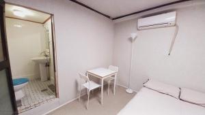 a room with a bed and a table and a bathroom at 1975 Yurim Inn in Seoul