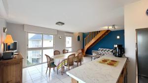 Una cocina y una sala de estar con mesa y sillas. en 390 Appartement 3 chambres avec vue sur la Grande Plage de Saint-Cast, en La Garde