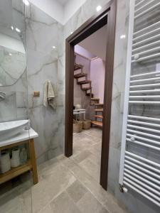uma casa de banho com um chuveiro, um lavatório e uma escada em Estia Alternative Apartment em Drama