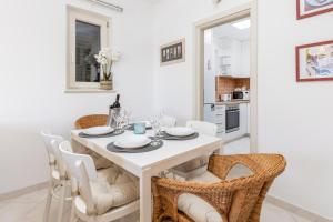 a white dining room with a white table and chairs at Lula la land (4 adults or family) in Herceg-Novi