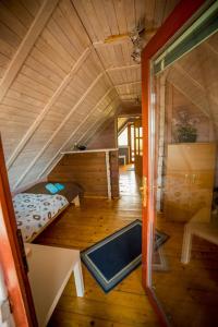 a small room with a bed in a wooden house at Domki Kątno in Stare Jabłonki