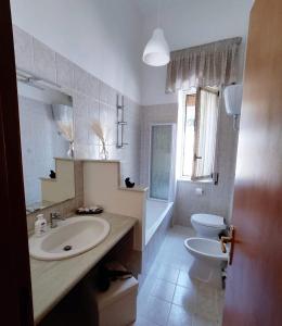 a white bathroom with a sink and a toilet at Nalusa Home in Sarno
