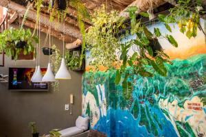 a room with potted plants hanging from the ceiling at LaTaperaJeri Hostel in Jericoacoara