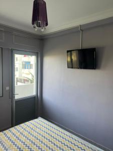 - une chambre avec un lit et une télévision murale dans l'établissement T3 beautiful apartment for rent, à Martil