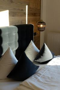 ein Bett mit schwarzen und weißen Kissen darauf in der Unterkunft My Place in Lautzenhausen