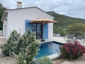 a house with a swimming pool and an umbrella at Villa bellevue, neuve, 6 pax, pisc. chauffée in Brando