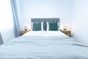 a bedroom with a large bed with green pillows at Slow River Apartment in Nowe Miasto Lubawskie