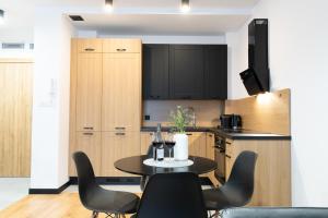 uma cozinha com mesa e cadeiras num quarto em Slow River Apartment em Nowe Miasto Lubawskie