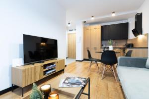 a living room with a couch and a tv and a table at Slow River Apartment in Nowe Miasto Lubawskie