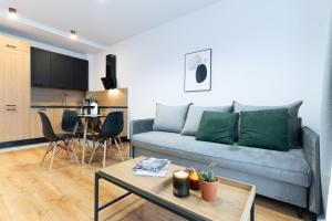 a living room with a couch and a table at Slow River Apartment in Nowe Miasto Lubawskie